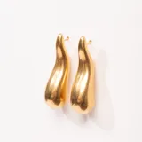 Aros colgantes dorados con forma de gota irregular.