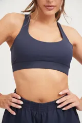 Top deportivo azul marino con tiras cruzadas en la espalda y elástico en la cintura.
