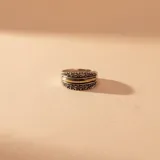 Anillo de plata y oro con diseño de banda ancha, decorado con dos filas de pequeñas circonias brillantes y una franja central de oro pulido.