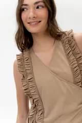 Musculosa cruzada de color beige, con escote en V y volados decorativos en los hombros y el frente.
