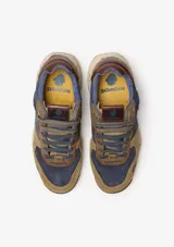 Championes urbanos Satorisan modelo Chacrona Premium, color verde caqui con detalles en negro y marrón. Presentan una entresuela con diseño jaspeado, suela con toques verdes y aplique circular negro en el lateral.