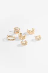 Set de tres pares de aros tipo argolla dorados, de diferentes tamaños y texturas: unos pequeños con textura de cuentas, otros medianos con diseño trenzado y unos más grandes de superficie lisa.