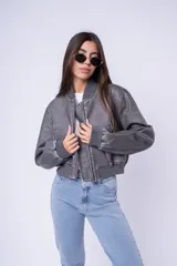 Campera tipo bomber de cuero sintético con efecto desgastado, cuello, puños y ruedo de tejido elástico acanalado, cierre frontal y bolsillos laterales.