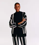 Saco de punto negro con estampado geométrico blanco, manga larga amplia y corte alargado.