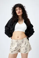 Short color crema con estampado abstracto en tonos grises, de tiro bajo y cintura elástica.