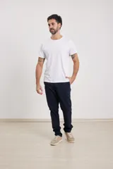 Pantalón chino de hombre, corte slim, color verde militar. Confeccionado en tejido de algodón con elastano, presenta triple pespunte en las costuras y botones al tono.
