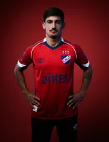 Camiseta de fútbol Umbro del Club Nacional de Football, modelo Away 2026 para hombre. Diseño principal en color rojo con detalles en azul marino y blanco en cuello, hombros y mangas, con patrón texturizado en la tela.