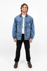 Campera de jean azul con cuello de corderito marrón, cierre con botones metálicos, cuatro bolsillos frontales y puños con botón.