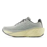 Championes de running New Balance modelo More V5, con tecnología Fresh Foam X en la entresuela para máxima amortiguación. Presentan un diseño de malla transpirable en color gris con detalles en turquesa y amarillo, y una suela voluminosa en tono crema.