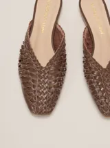 Mules de cuero marrón con diseño trenzado artesanal, punta fina y calce abierto.