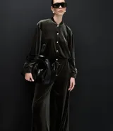 Campera bomber de terciopelo color verde oscuro, con cuello redondo, cierre frontal con botones metálicos, bolsillos laterales y mangas largas con puños elásticos.