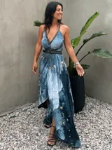 Vestido largo verde con diseño estampado tipo tie-dye y detalles dorados, de corte fluido, un solo hombro y diseño amplio.