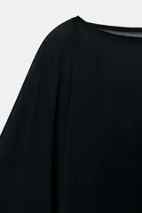 Vestido corto de tejido satinado con superposición de capa de gasa semitransparente. Presenta un diseño fluido con escote redondo y corte asimétrico.