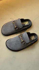 Mocasines color marrón de cuero gamuzado con detalle de hebilla dorada.