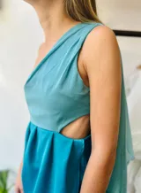 Vestido corto turquesa de un hombro con volado de gasa y corte en la cintura.