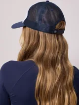 Gorra azul marino de lona con visera curva y malla trasera. Presenta logo bordado en el frente.