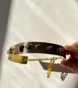 Gargantilla rígida dorada con piezas irregulares de bronce soldadas.