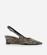 Zapato tipo slingback con estampado de piel de serpiente, puntera fina y taco anabela de 5 cm. Cuenta con tira ajustable en el talón con hebilla metálica.