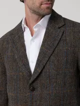 Blazer Harblaze de lana Harris Tweed color gris con patrón de cuadros y espiga, solapas de muesca, cierre de dos botones y bolsillos con solapa.