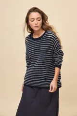 Sweater de tejido amplio en color azul marino con diseño de rayas horizontales y detalles calados. Cuenta con cuello redondo, mangas largas con hombros caídos y terminaciones acanaladas.