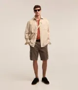 Bermuda cargo de algodón color blanco, con bolsillos laterales y traseros, cierre con botón y cremallera.