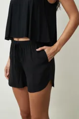 Shorts de mujer color negro con estampado de piel de serpiente, tiro alto y cordón ajustable en la cintura.