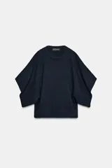 Jersey de punto con cuello redondo y mangas anchas tipo murciélago. Presenta un diseño de corte holgado con terminaciones en rib a tono en el cuello, puños y bajo.