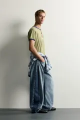 Jeans loose balloon fit de denim de algodón con diseño de cinco bolsillos y efecto lavado. Presentan bandas laterales en contraste y cierre frontal con cremallera y botón.