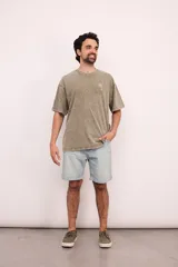 Camiseta de corte oversize color verde con efecto lavado, cuello redondo y pequeño estampado de una palmera en el pecho.