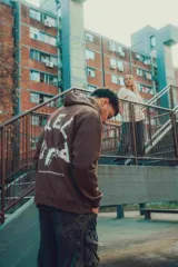 Hoodie color crema de corte oversize con capucha y logo pequeño en el pecho.