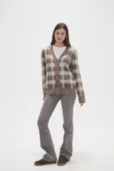 Cardigan de punto con diseño de cuadros, cuello en V y cierre frontal con botones. Presenta un corte holgado y mangas largas.