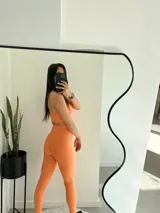 Calza deportiva larga color durazno, tiro alto y textura acanalada.