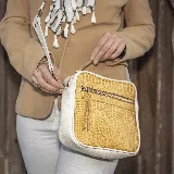 Bandolera de cuero vacuno color amarillo con textura tipo piel de cocodrilo y laterales blancos. Tiene correa larga ajustable y removible, bolsillo externo con cierre y forro interior de tela con bolsillo interno con cierre.