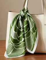 Pañuelo cuadrado de seda con estampado floral en tonos verde, blanco y negro.