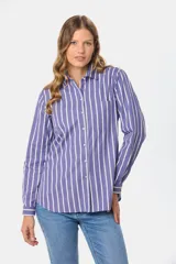 Camisa holgada de manga larga, color azul con rayas verticales blancas, cuello clásico y bolsillo en el pecho.