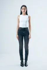 Jean de corte skinny y tiro medio, confeccionado en denim elástico de color gris oscuro con efecto lavado. Presenta diseño clásico de cinco bolsillos, cierre frontal con botón y presillas en la cintura.