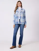 Sobrecamisa de tejido soft con estampado de cuadros en tonos azules y blancos. Presenta cuello con solapa, cierre frontal con botones, bolsillos aplicados en el pecho y mangas largas con puños abotonados. El interior cuenta con un acabado afelpado.