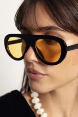 Lentes de sol con armazón negro de diseño envolvente y cristales amarillos con protección UV400.