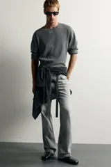 Jeans flare fit de denim de algodón en color gris con efecto lavado. Presentan diseño de cinco bolsillos, tiro medio y cierre frontal con cremallera y botón.