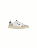 Championes Autry modelo Medalist Low, de cuero blanco con detalles en gamuza beige en la puntera y el talón. Presenta cordones al tono, suela de goma color crema y logo de la marca con la bandera estadounidense en el lateral.