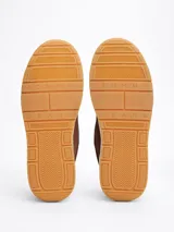 Zapatillas Tommy Jeans de corte bajo, color marrón, confeccionadas en gamuza con interior de poliéster y suela de goma. Presentan cordones, entresuela texturizada, etiqueta de la marca en el lateral y parche en la lengüeta.