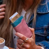 Billetera tarjetero automática con estructura de aluminio y revestimiento de cuero bicolor en tonos verde oliva y beige. Cuenta con un cierre de broche a presión y el logo de la marca grabado en la parte inferior.