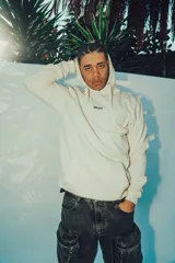 Hoodie color crema de corte oversize con capucha y estampa en la espalda.