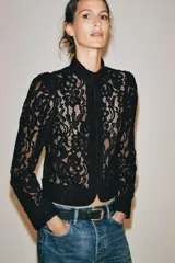 Blazer de encaje negro con hilatura de algodón, cuello redondo, manga larga y cierre frontal de botones.