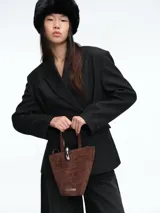 Blazer de corte sastrero con diseño de doble botonadura y solapas clásicas. Presenta un patrón de rayas verticales finas, hombros estructurados y bolsillos con solapa en la parte frontal.