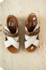 Sandalias de cuero color tostado y blanco, con plataforma track y hebilla metálica.