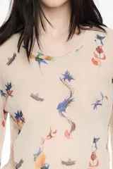 Camiseta de manga larga, corte ajustado, confeccionada en tul de poliamida con estampado de insectos y motivos florales en tonos azules, naranjas y verdes sobre fondo beige claro. Presenta cuello caja y puños con acabado en crudo.