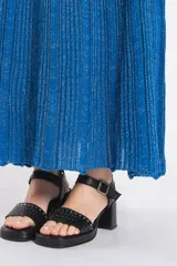 Vestido largo de tejido de punto azul con brillo, sin mangas, escote cuadrado y diseño acampanado.