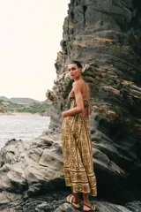 Vestido midi de broderie en tonos mostaza y marrón, con escote en V, tirantes finos ajustables, abertura cut-out en la cintura y espalda con nido de abeja elástico.