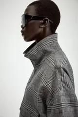 Chaqueta estilo bomber con estampado de cuadros, cuello subido, manga larga y cierre frontal con cremallera. Presenta bolsillos delanteros y bajo elástico.